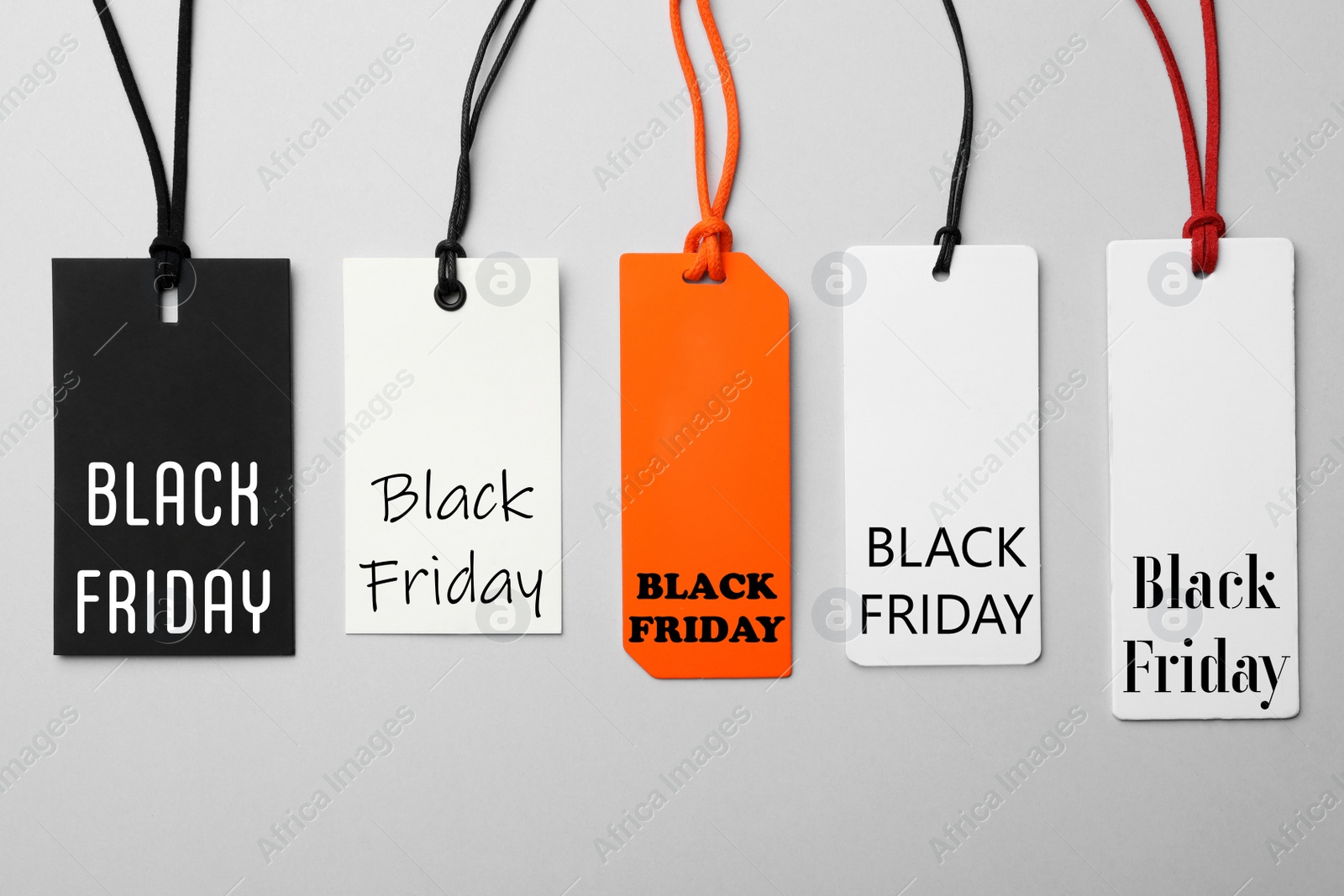 Image of Different tags with text BLACK FRIDAY on light background, flat lay