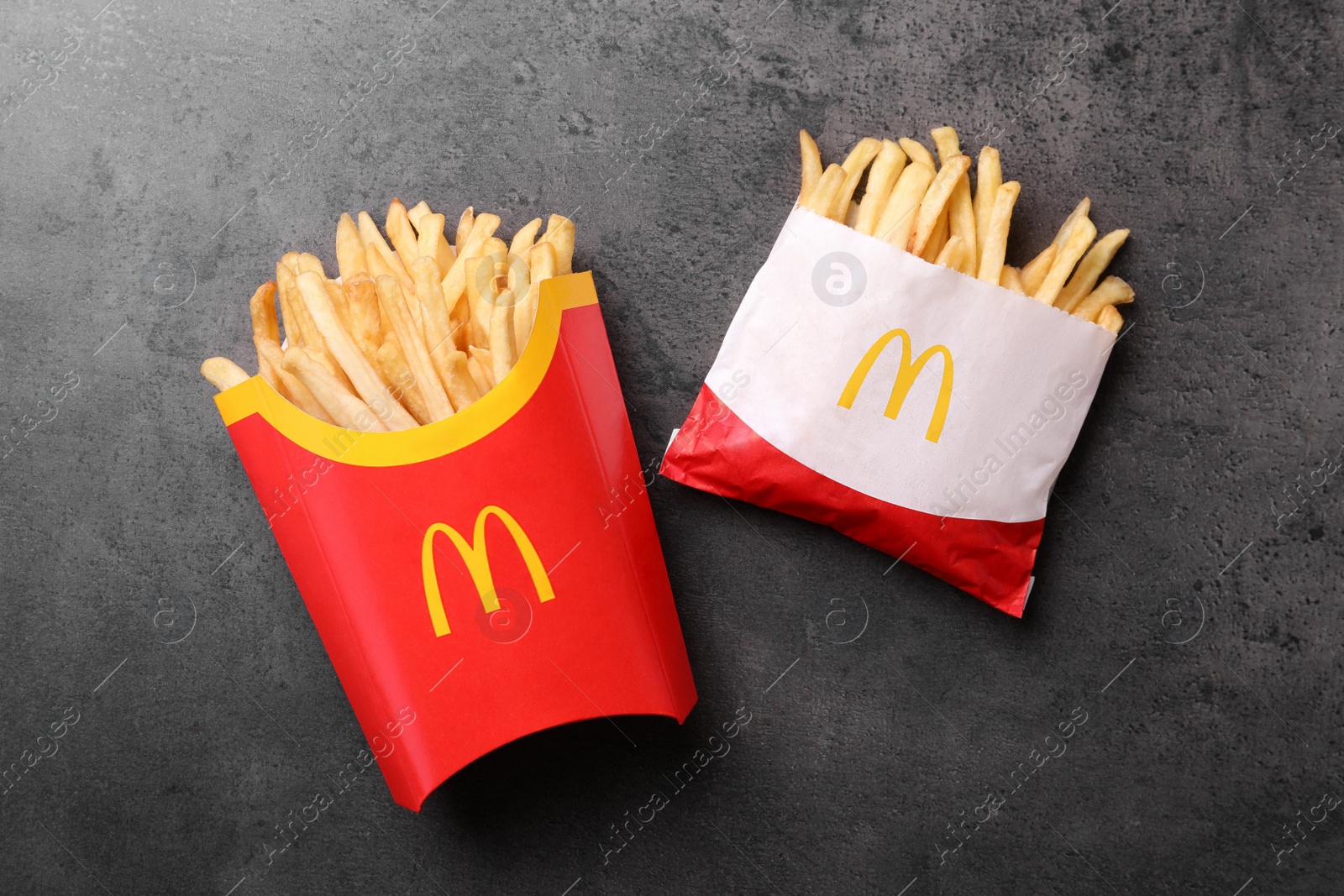 Photo of MYKOLAIV, UKRAINE - AUGUST 12, 2021: Small and big portions of McDonald's French fries on grey table, flat lay