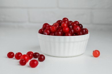 Photo of Ripe cranberries in bowl on white table