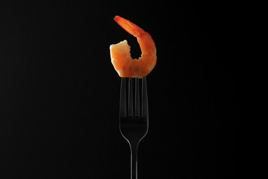 Photo of Fork with one shrimp on black background