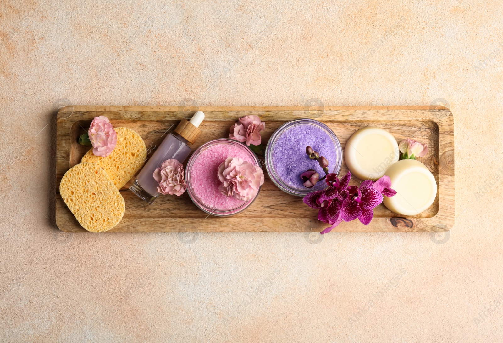 Photo of Aromatic sea salt and spa products on beige textured table, top view