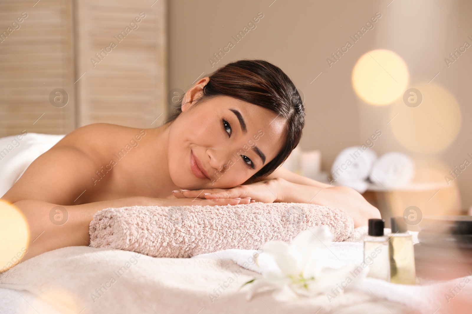 Photo of Beautiful Asian woman lying on massage table in spa salon