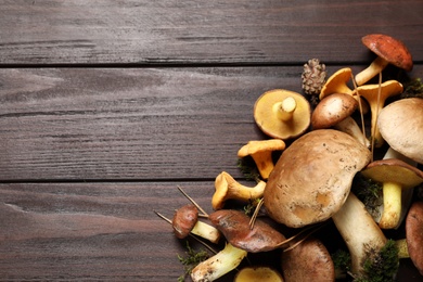 Photo of Flat lay composition with fresh mushrooms on wooden table, space for text