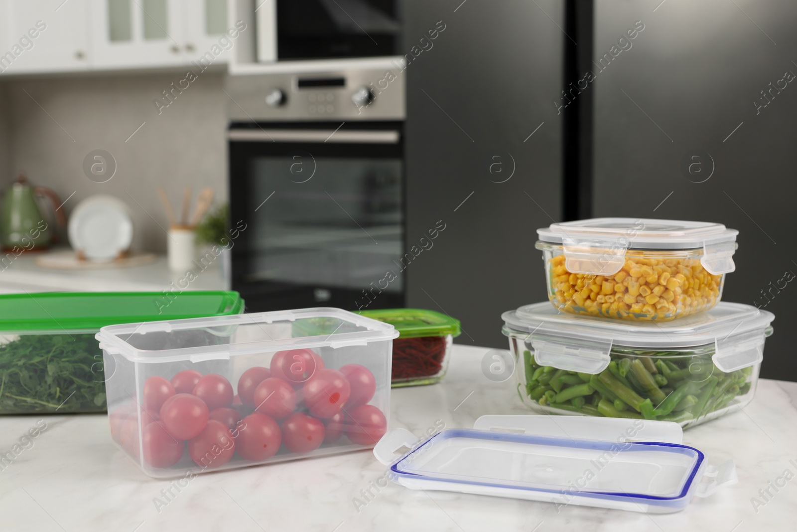 Photo of Plastic and glass containers with different fresh products on white marble table in kitchen, space for text. Food storage