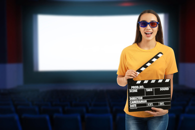Image of Young woman with clapperboard and 3D glasses in cinema, space for text