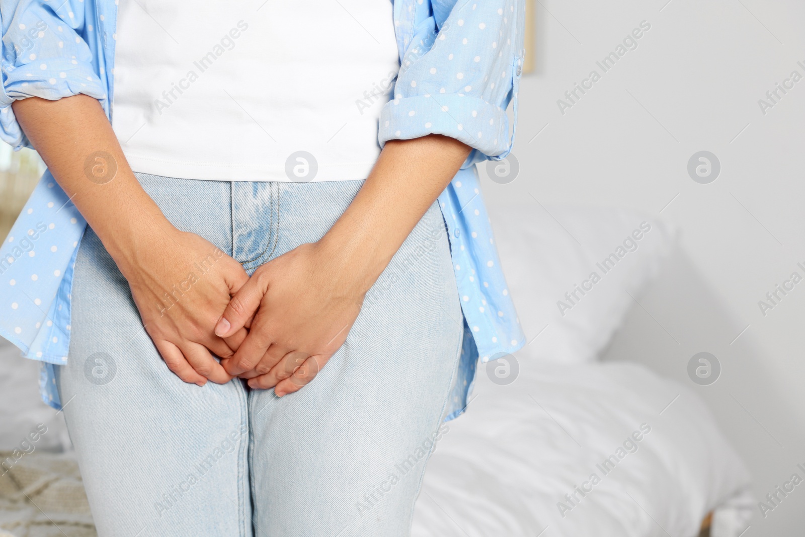 Photo of Woman suffering from genital herpes in bedroom, closeup. Space for text