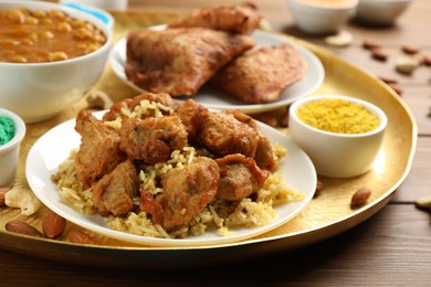 Photo of Traditional Indian food and color powder on wooden table, closeup. Holi festival celebration