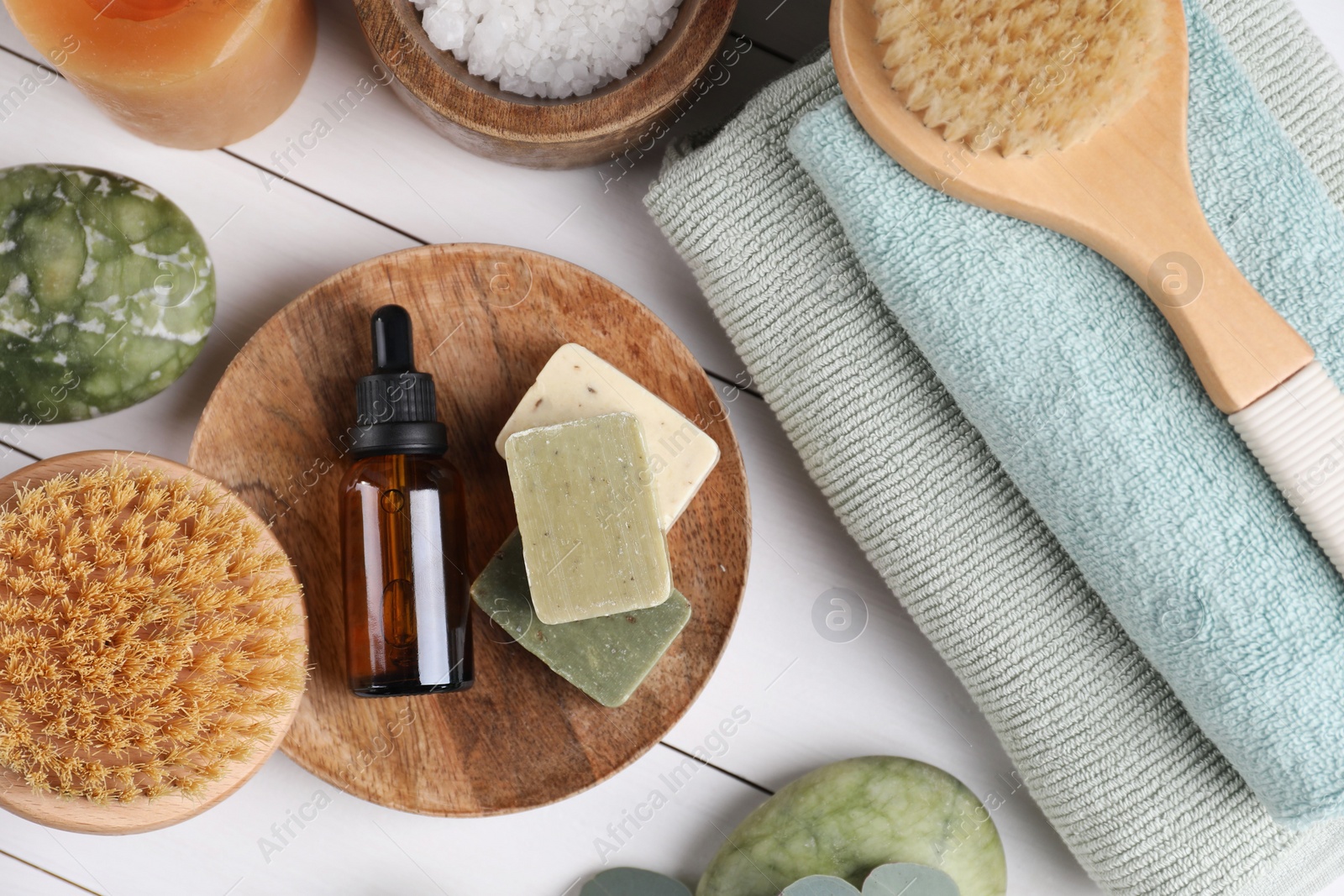 Photo of Flat lay composition with different spa products and burning candle on white wooden table