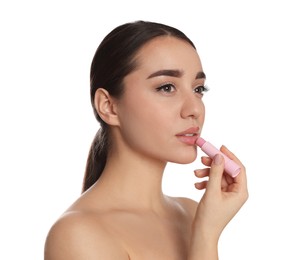 Photo of Young woman applying lip balm on white background