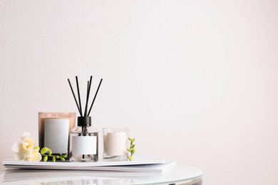 Composition with aromatic reed air freshener on white table, space for text