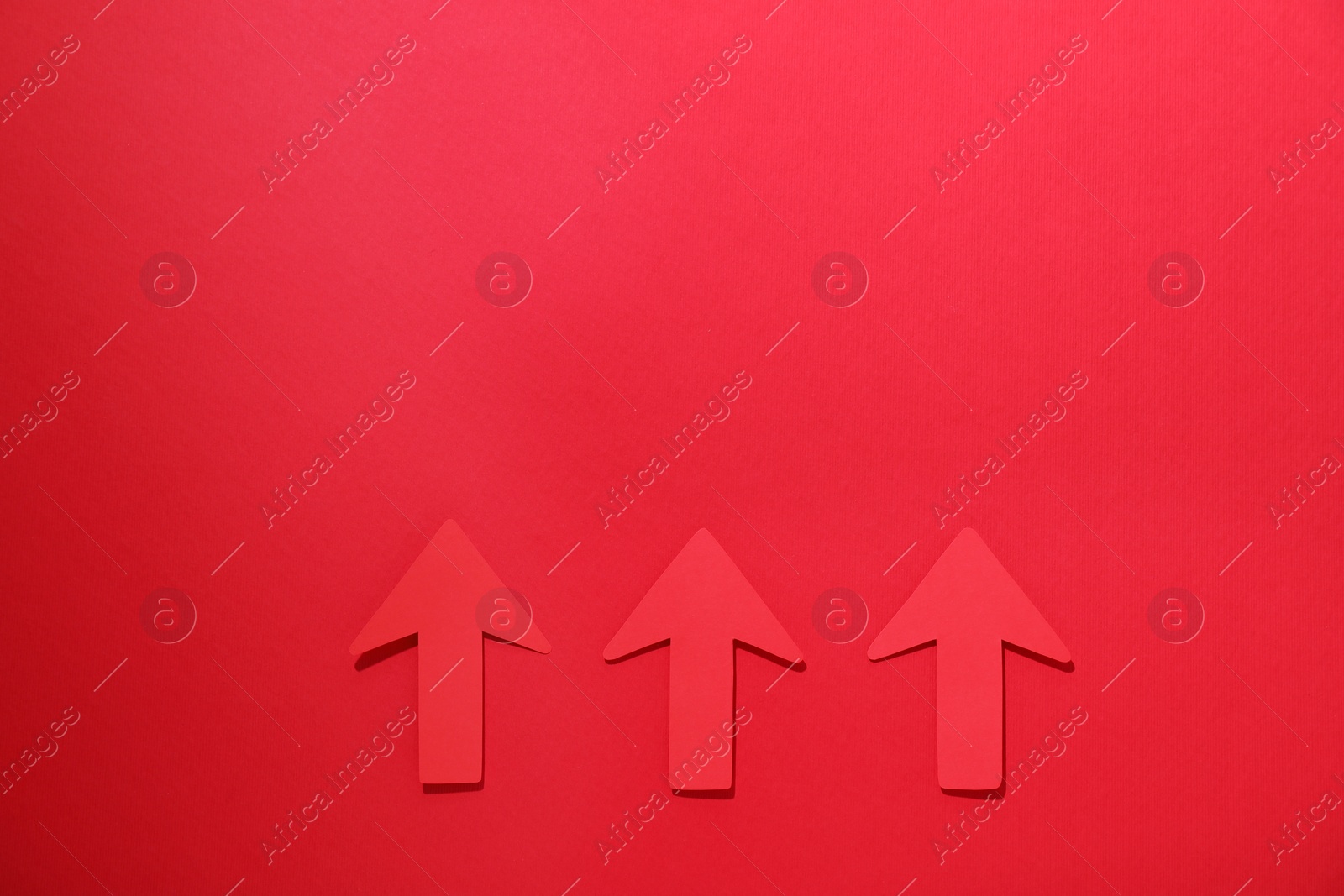 Photo of Paper arrows on red background, flat lay. Space for text