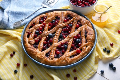 Photo of Delicious currant pie and fresh berries on white wooden table