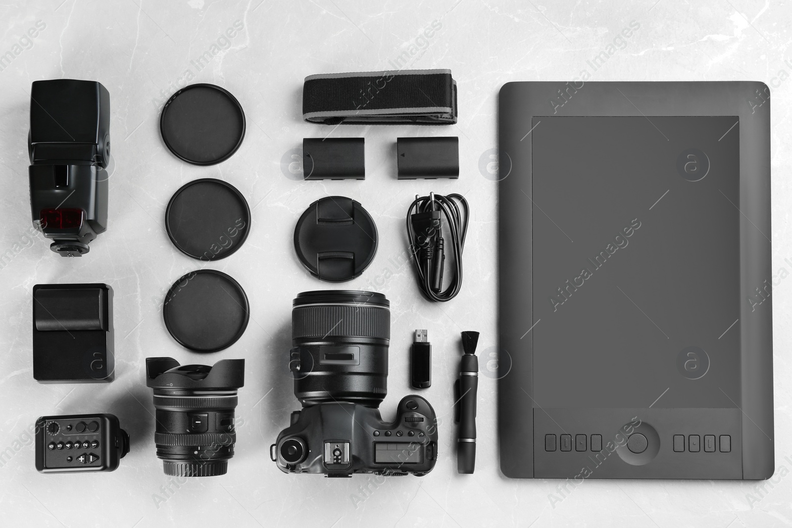 Photo of Flat lay composition with equipment for professional photographer on grey marble table