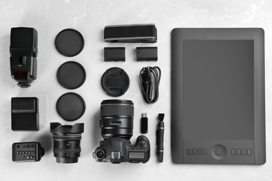 Photo of Flat lay composition with equipment for professional photographer on grey marble table