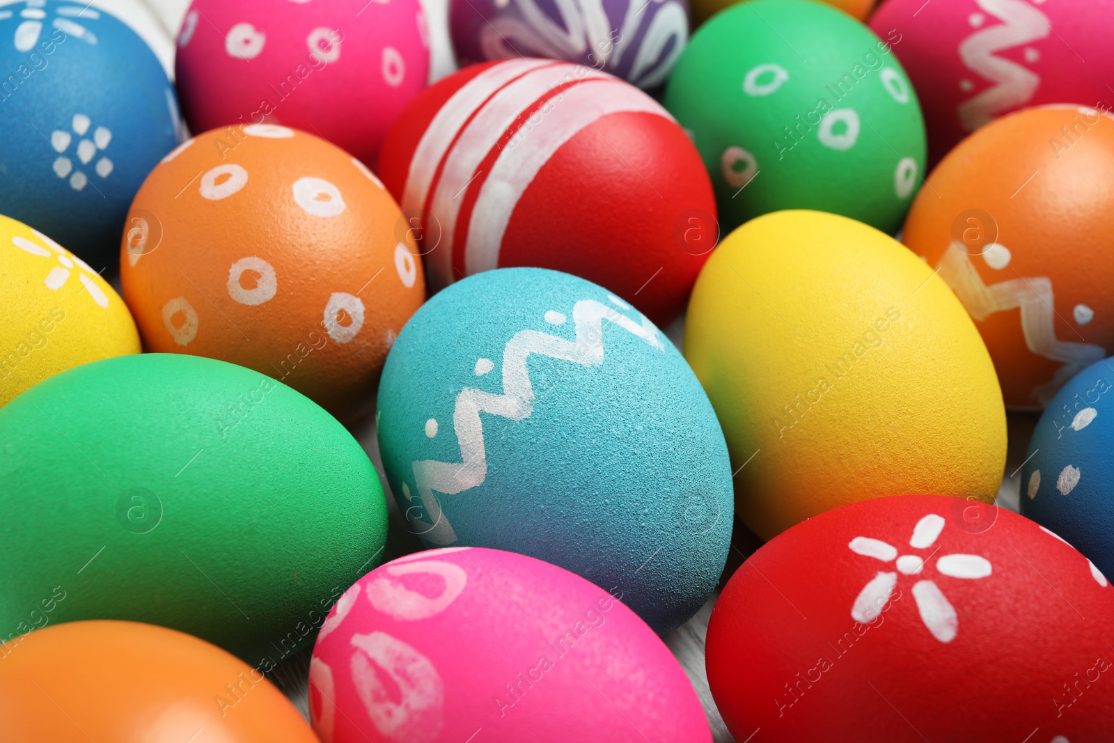 Photo of Many bright Easter eggs as background, closeup view