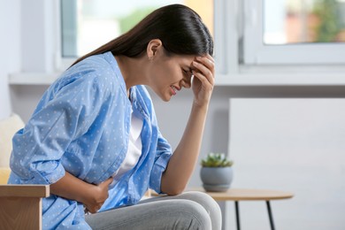 Young woman suffering from menstrual pain at home
