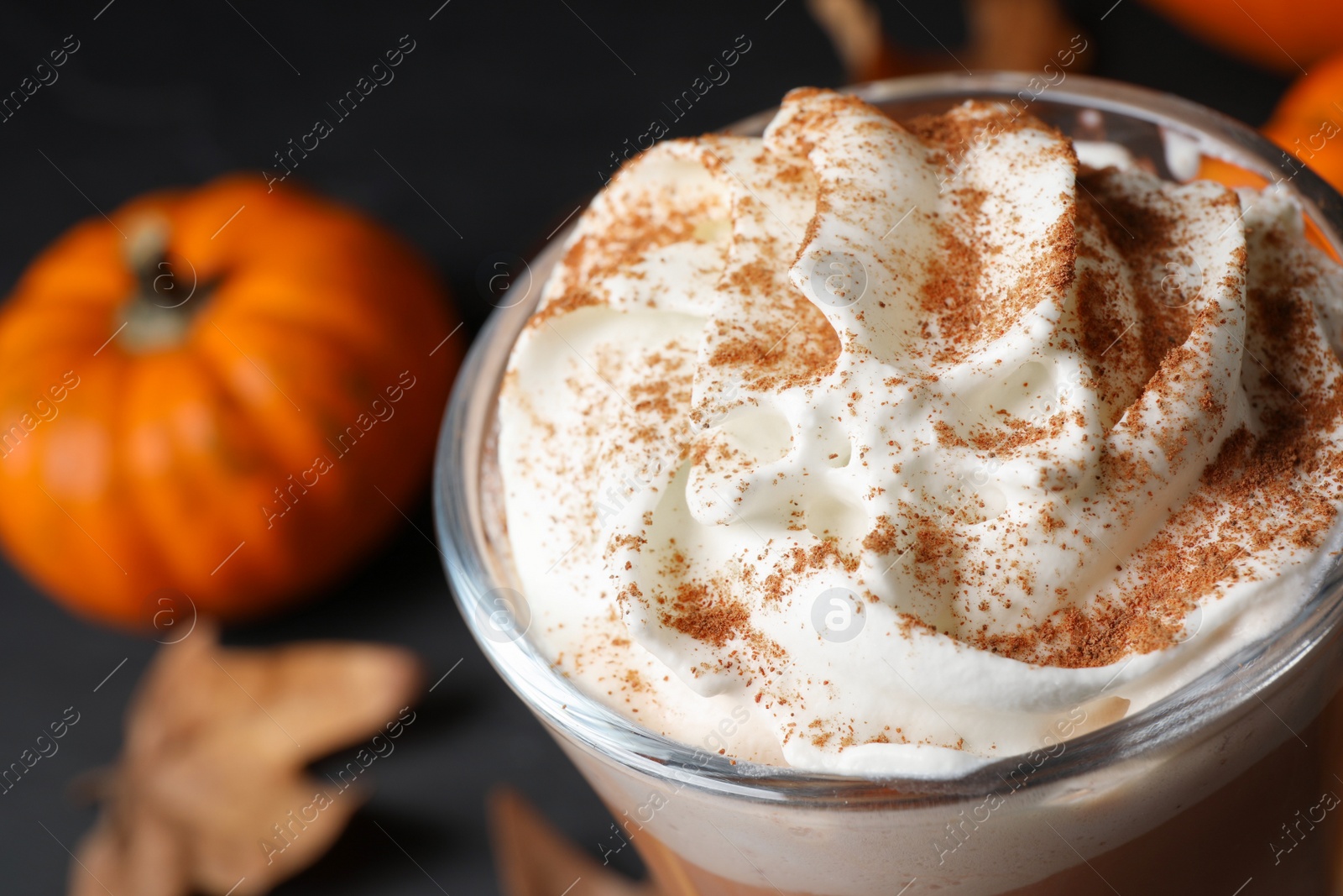 Photo of Delicious pumpkin latte with whipped cream on table, closeup