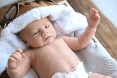 Photo of Cute newborn baby in aviator hat on blanket, closeup