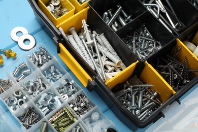Photo of Organizers with many different fasteners on light blue wooden table, above view