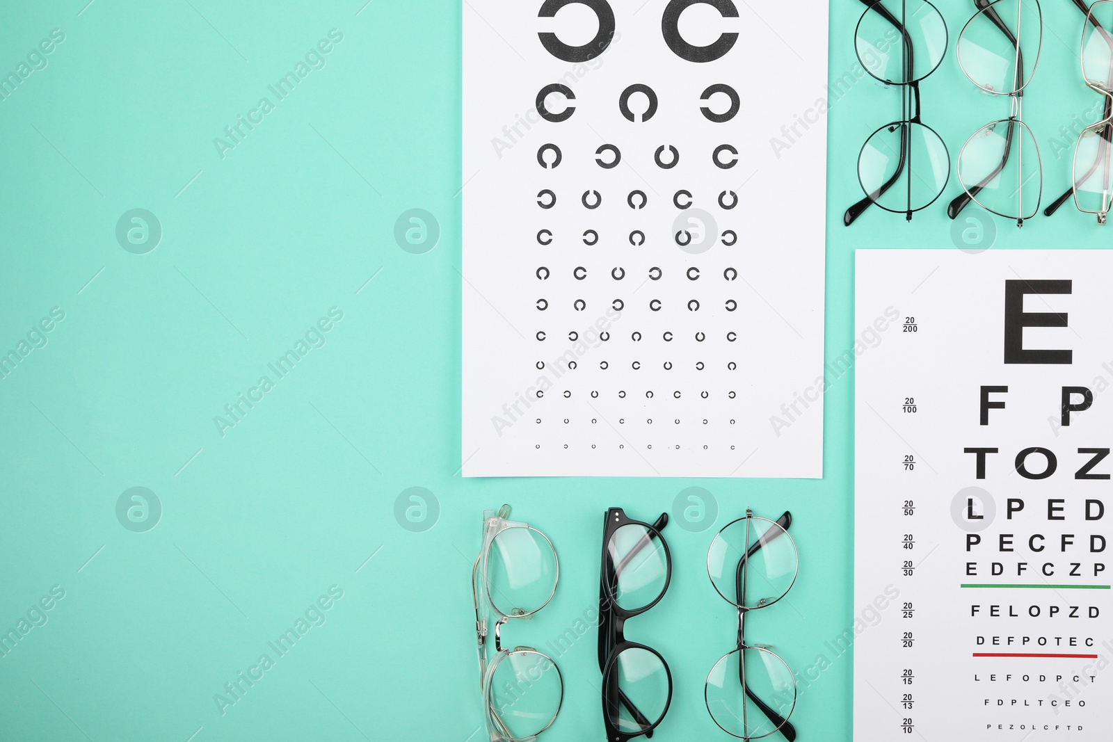 Photo of Vision test chart and glasses on turquoise background, flat lay. Space for text