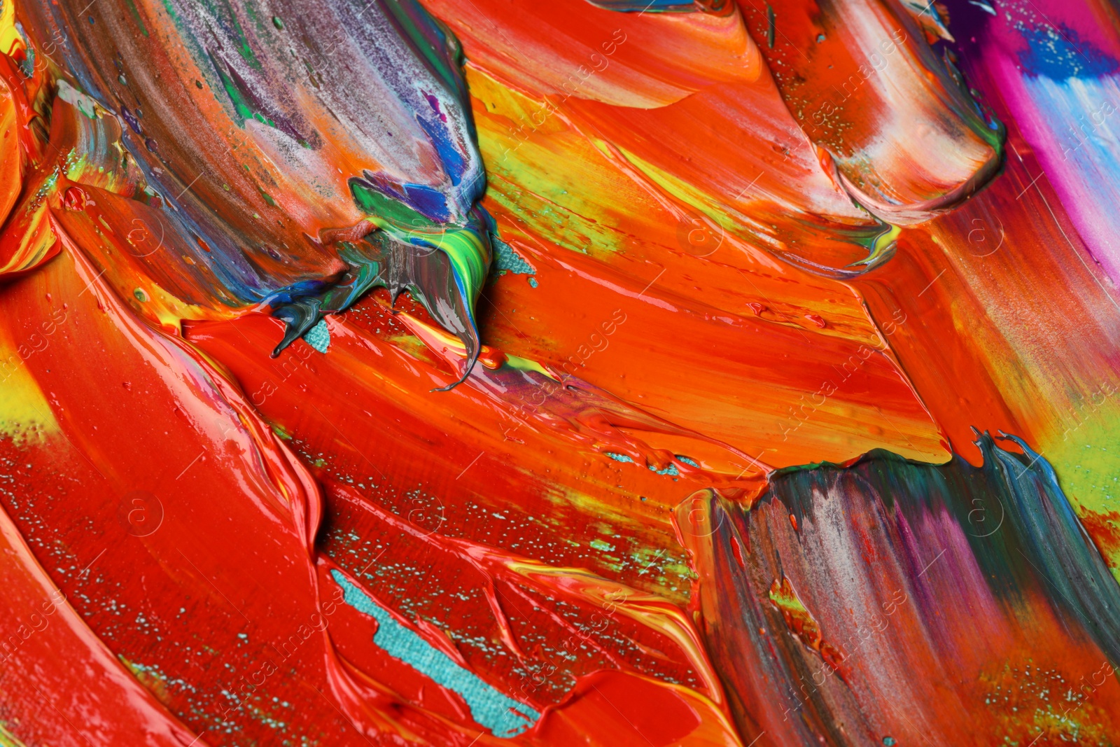 Photo of Strokes of colorful acrylic paints as background, closeup view