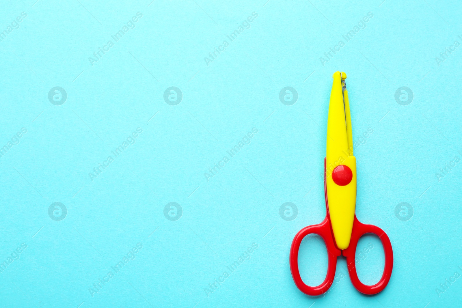 Photo of Decorative edge scissors on color background, top view. Space for text