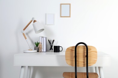 Photo of Comfortable workplace with white desk near wall at home