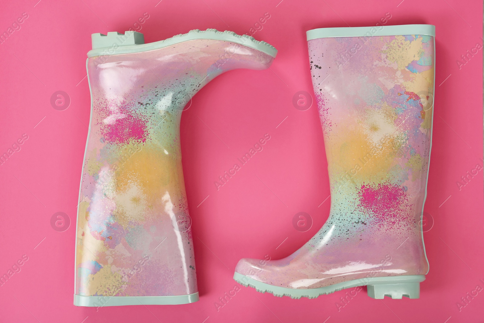 Photo of Pair of gumboots on color background, top view. Female shoes