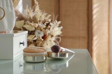 Photo of Wooden dressing table with makeup products in room