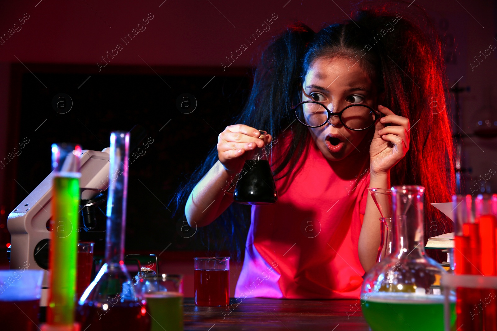 Photo of Child doing chemical research in laboratory. Dangerous experiment