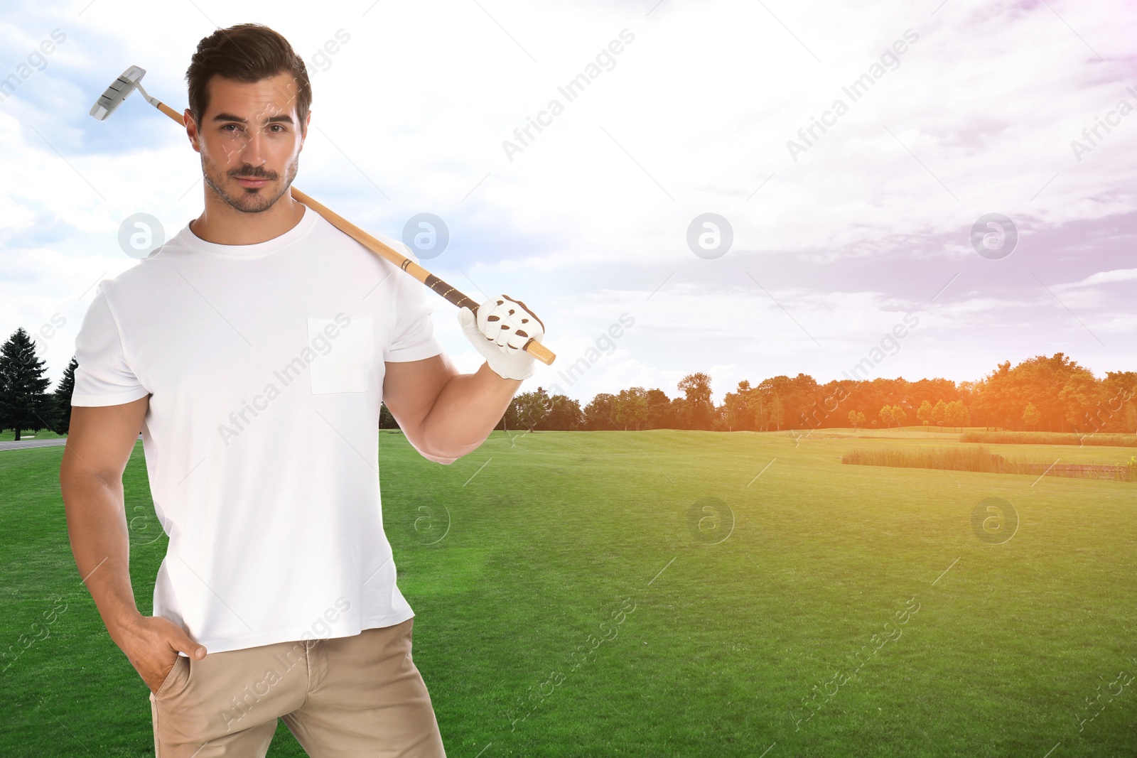 Image of Young man with golf club on green course. Space for design