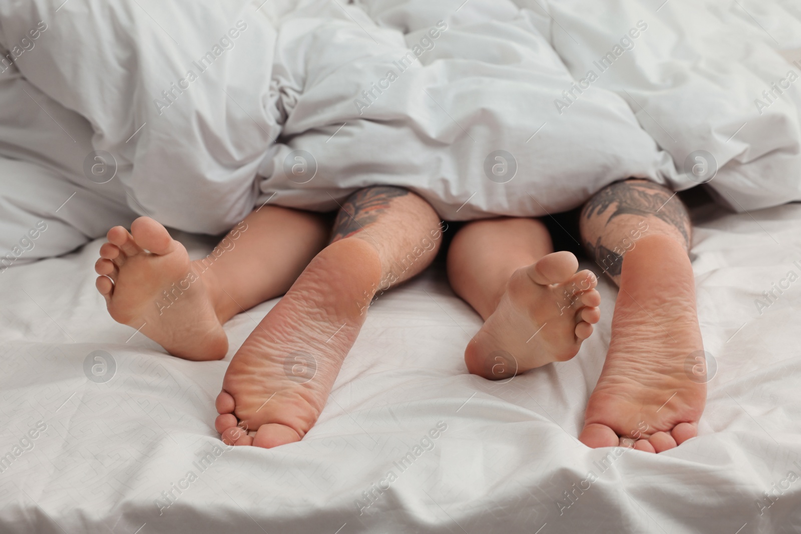 Photo of Passionate couple having sex on bed, closeup of legs