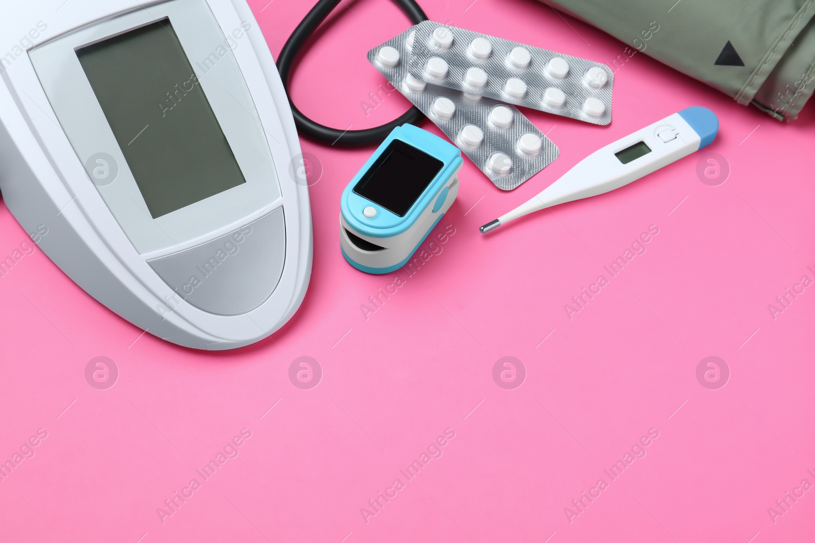 Photo of Digital pressure meter and medical objects on color background. Space for text