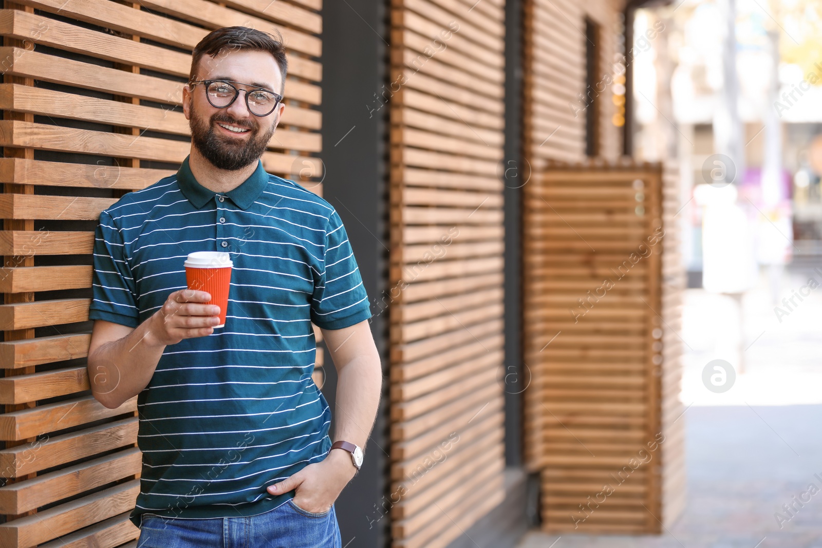 Photo of Portrait of young man with cup of coffee outdoors