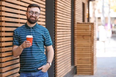 Photo of Portrait of young man with cup of coffee outdoors