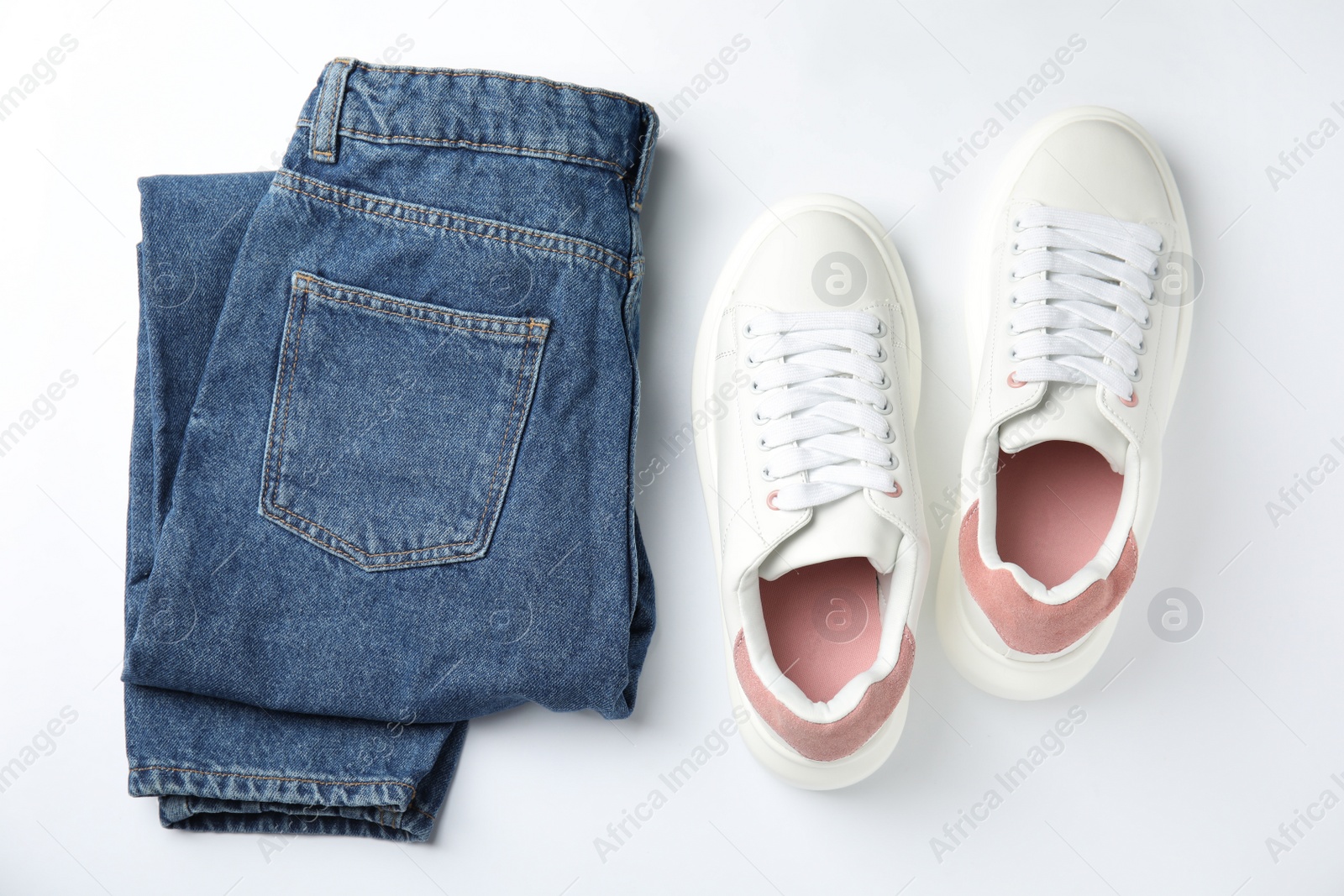 Photo of Stylish sneakers and jeans on white background, flat lay