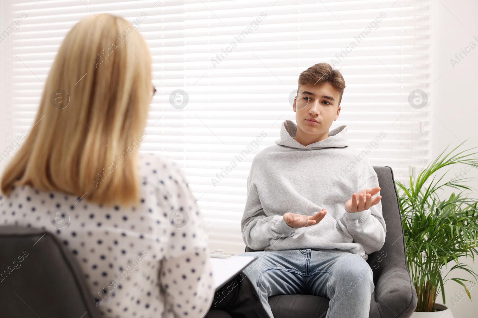 Photo of Psychologist working with teenage boy in office