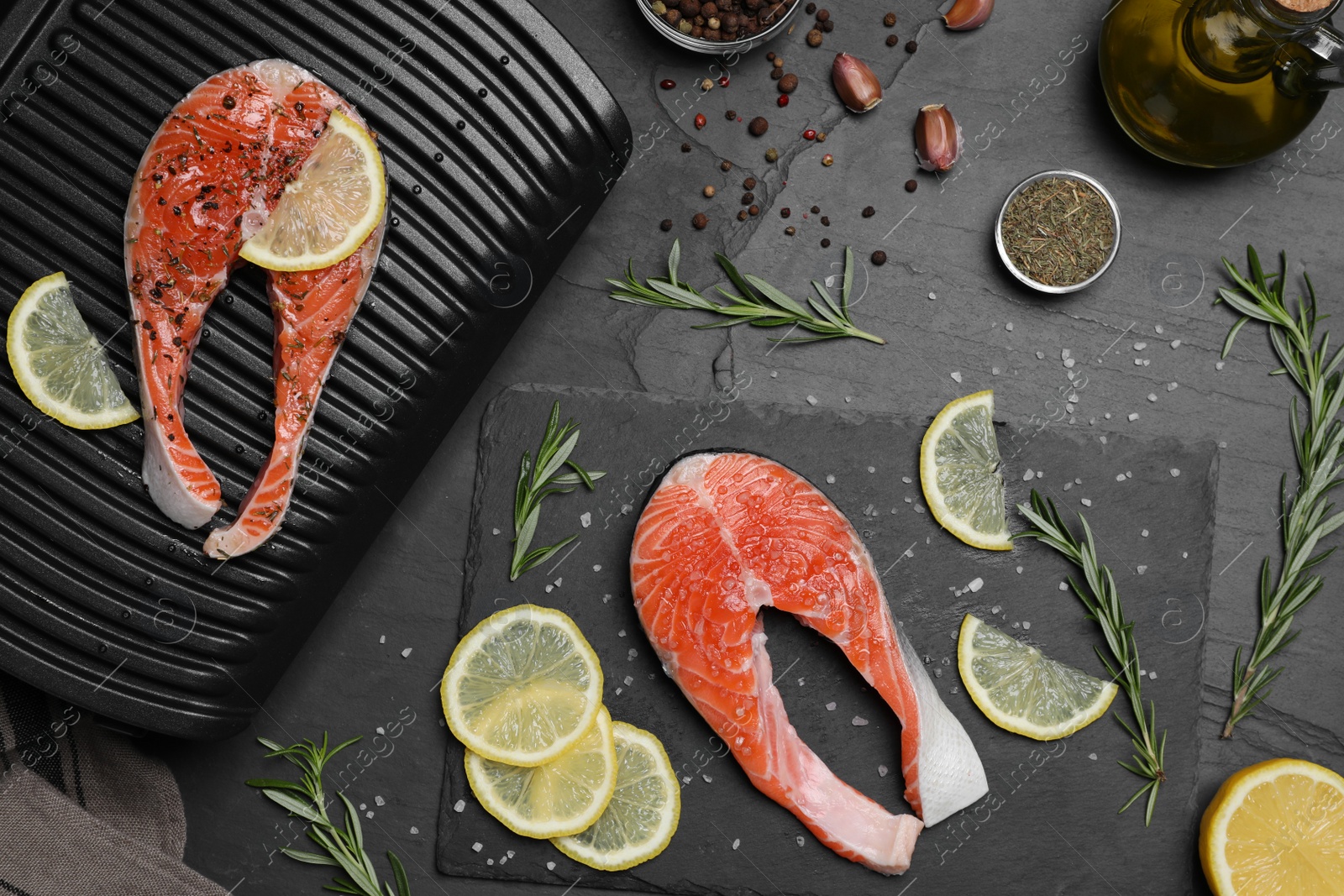 Photo of Cooking salmon. Grill, fresh fish steaks, lemon and spices on dark table, flat lay