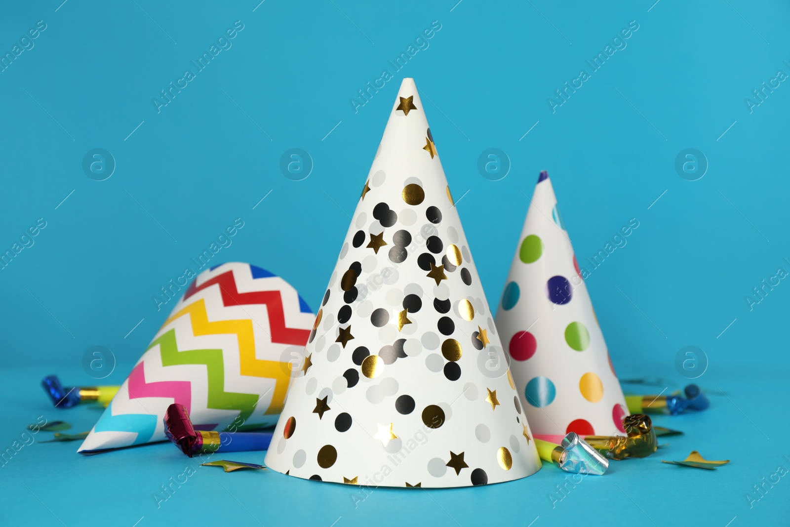 Photo of Colorful party hats and festive items on light blue background