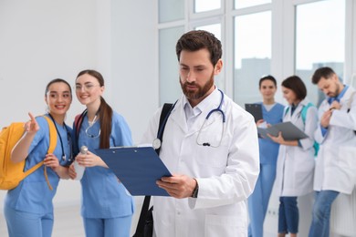 Photo of Smart medical student with clipboard in college hallway