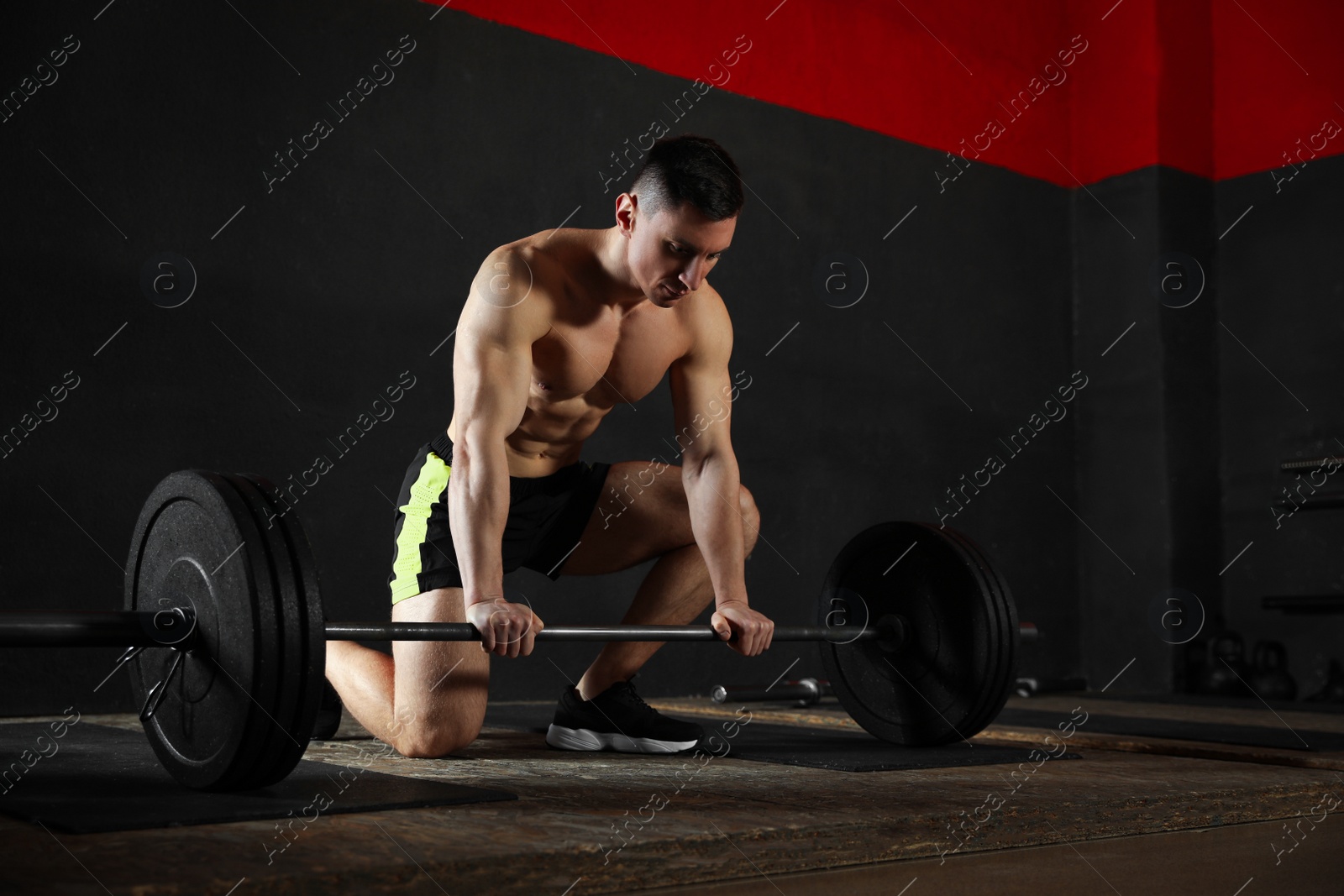 Photo of Strong man lifting barbell in modern gym