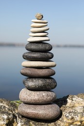 Stack of stones on rock near sea. Harmony and balance concept
