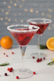 Photo of Tasty cranberry cocktail in glasses on white table