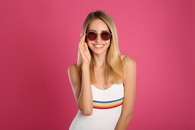 Photo of Beautiful woman in stylish sunglasses on pink background