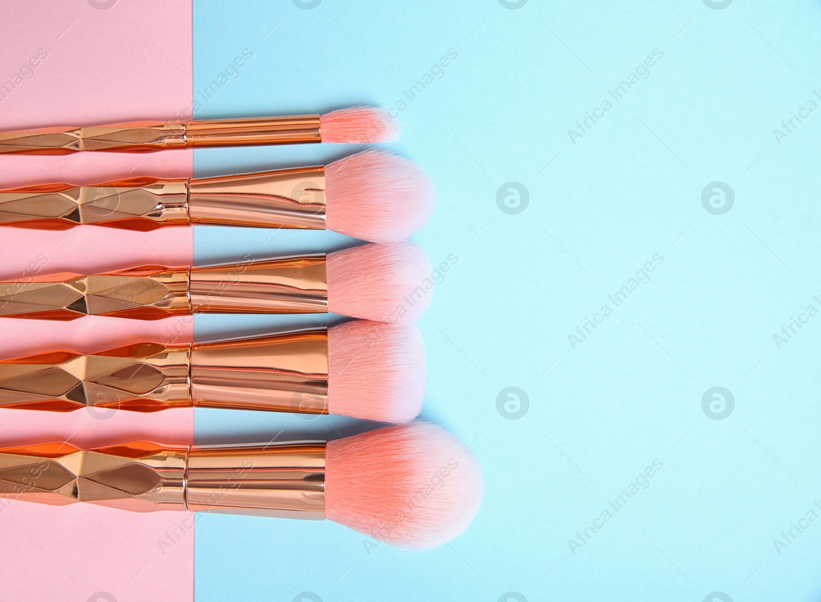 Photo of Flat lay composition with set of professional makeup brushes on color background. Space for text