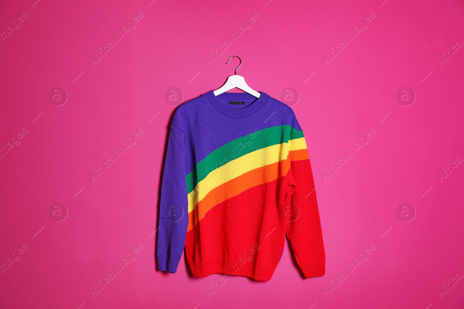 Photo of Hanger with stylish sweater on color background