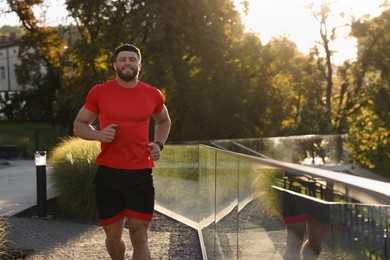 Happy man running outdoors on sunny day. Space for text