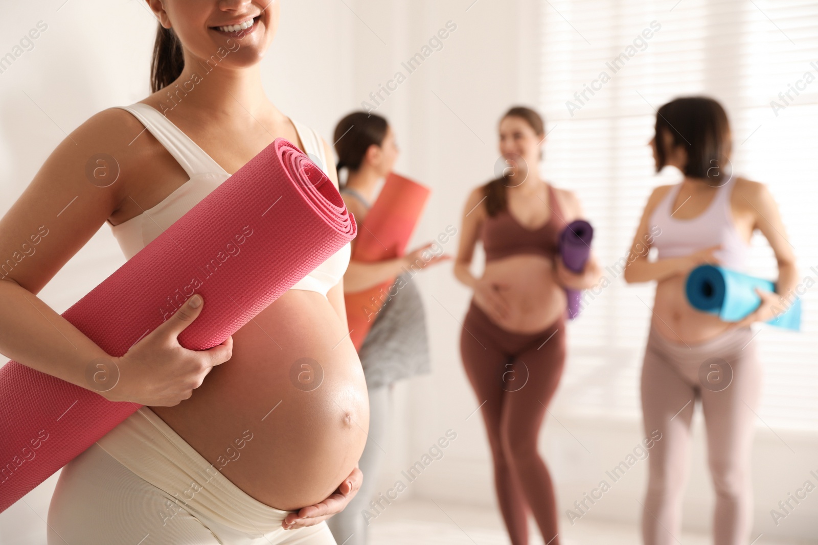 Photo of Group of pregnant women with mats in yoga class, closeup. Space for text