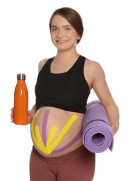 Sporty pregnant woman with kinesio tapes holding water bottle and mat on white background