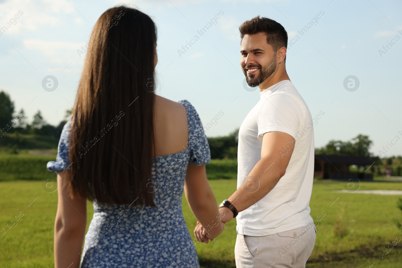 Photo of Romantic date. Beautiful couple walking outdoors on sunny day